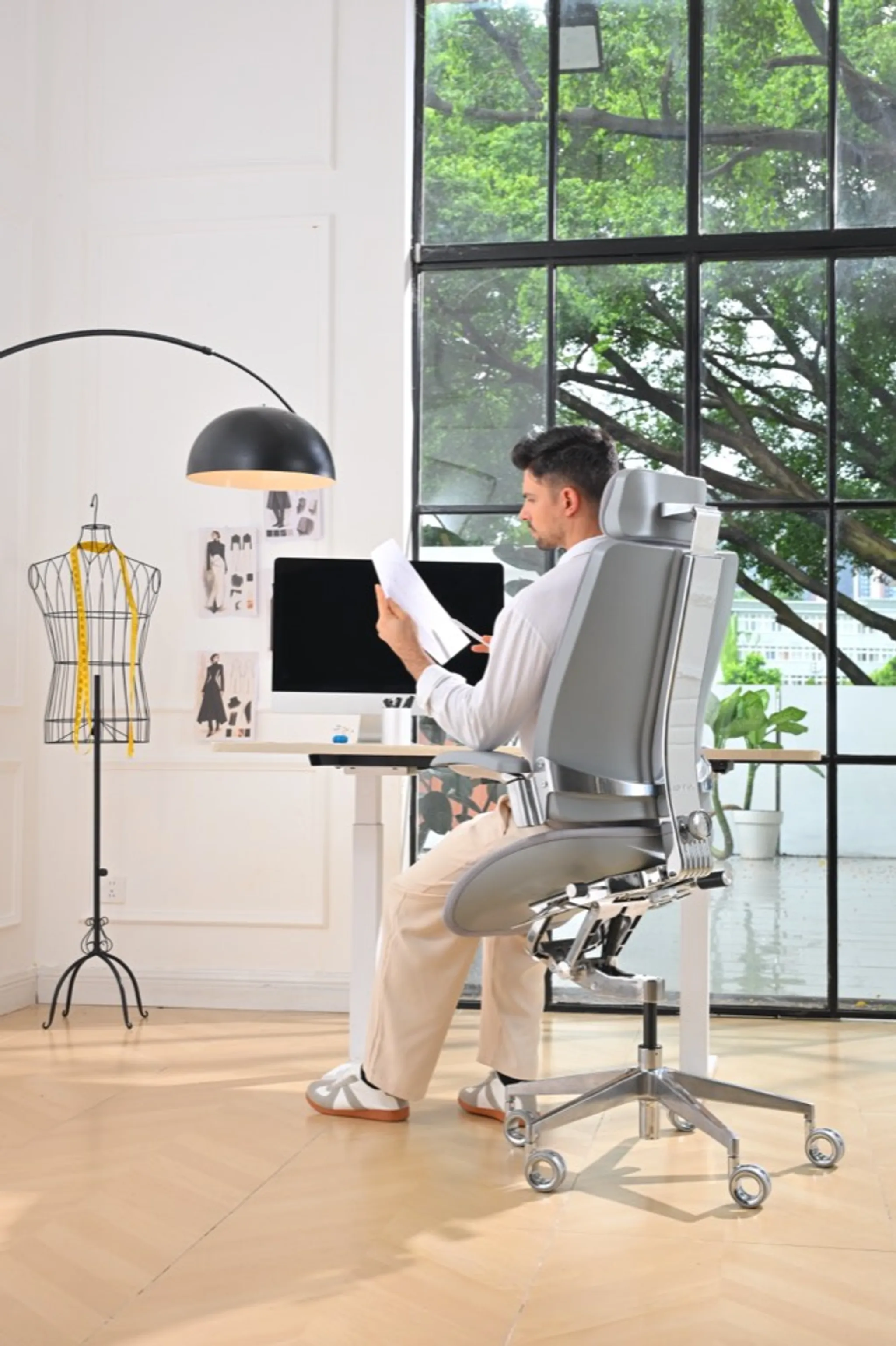 Split scene of one worker leaning forward on a forward-tilt chair and another reclined in a standard ergonomic task chair.