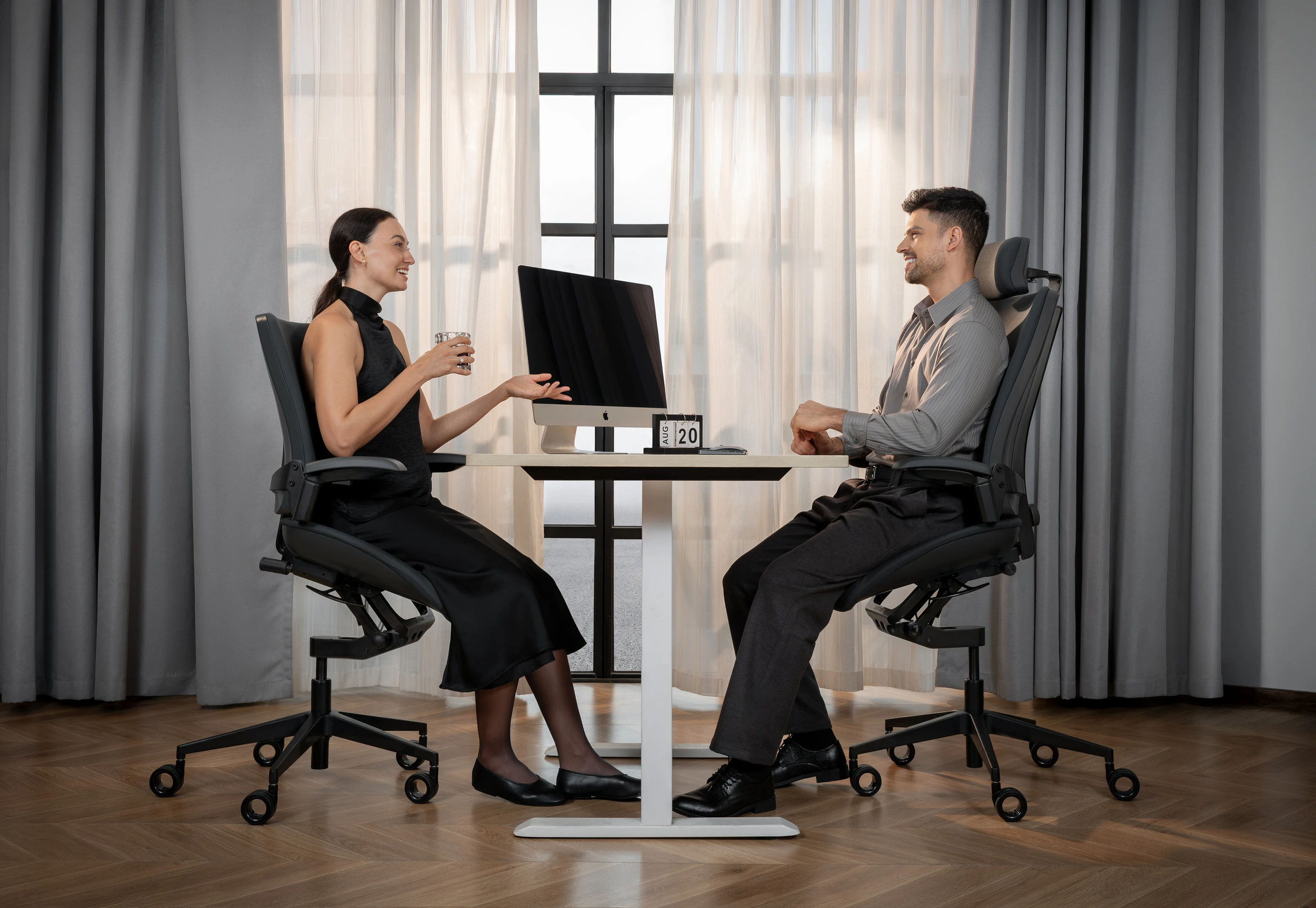 Two people using the Vision Chair at a height-adjustable desk. © Levitask Limited